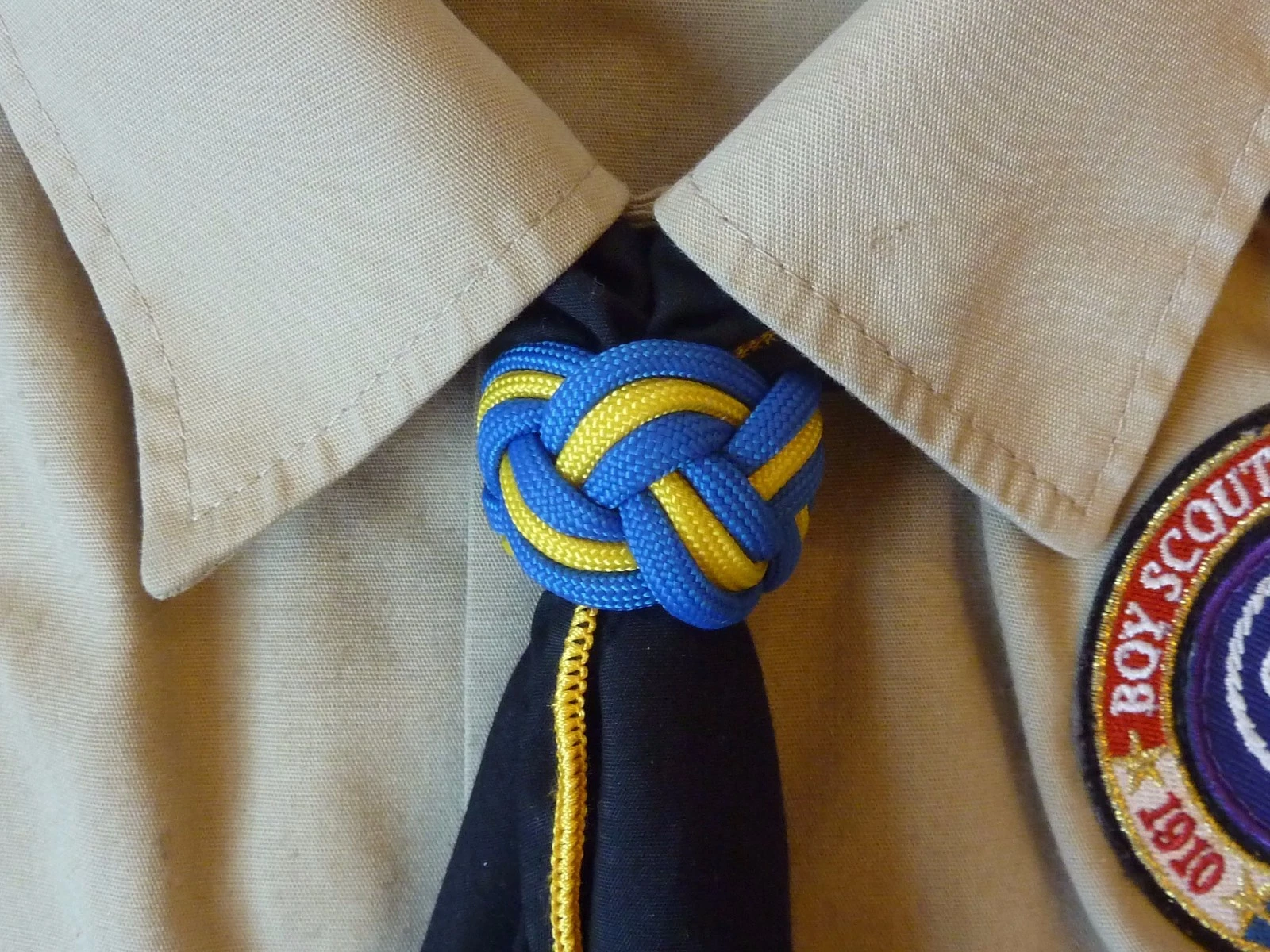 Blue and yellow Turk's head neckerchief slide worn on a Scout neckerchief.