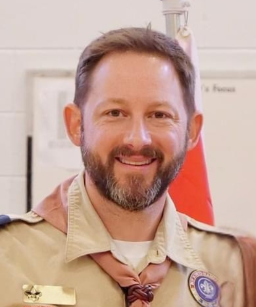 Leader in Scout uniform, smiling toward the camera.